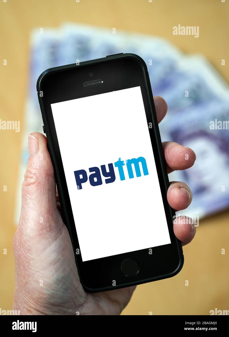 A woman looking at the Pattm e-commerce payment company logo on a mobile phone. (editorial Use Only) Stock Photo