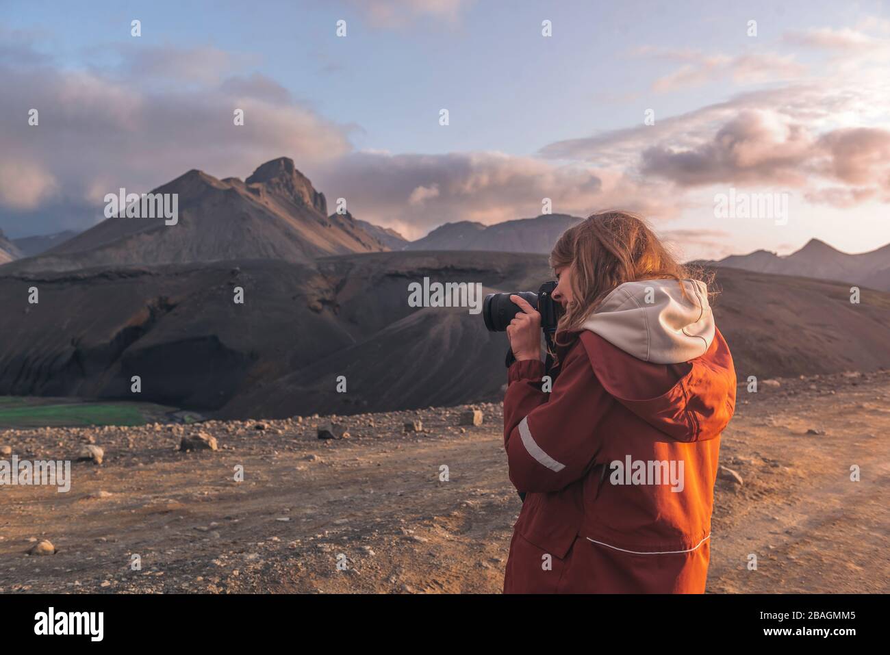 Young woman taking photographs of mountains in highlands of Iceland Stock Photo