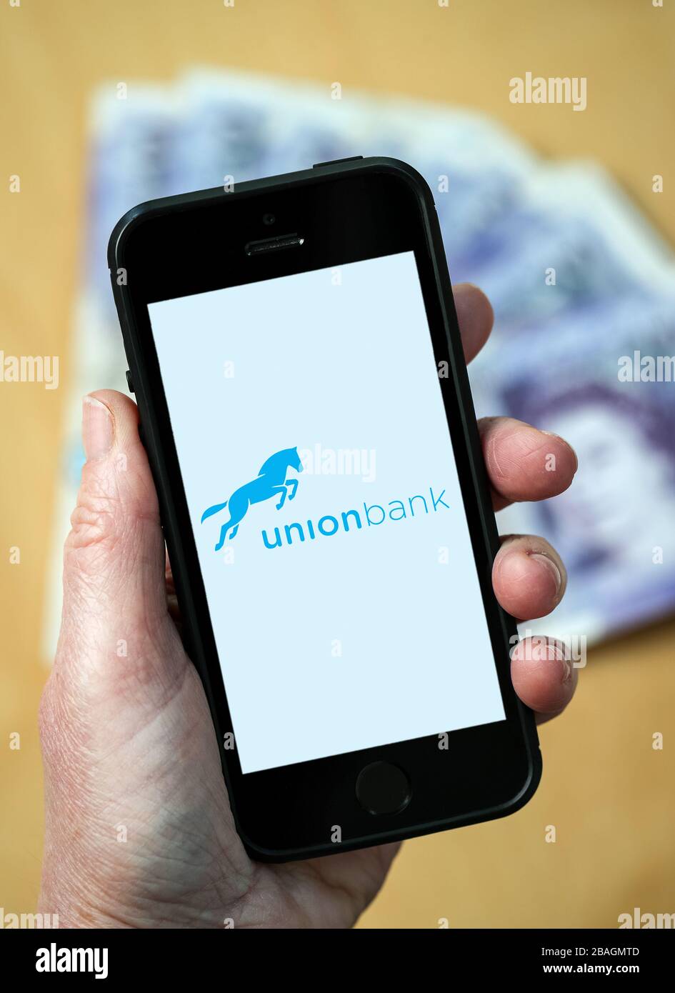 A woman looking at the Union Bank logo on a mobile phone. (editorial Use Only) Stock Photo