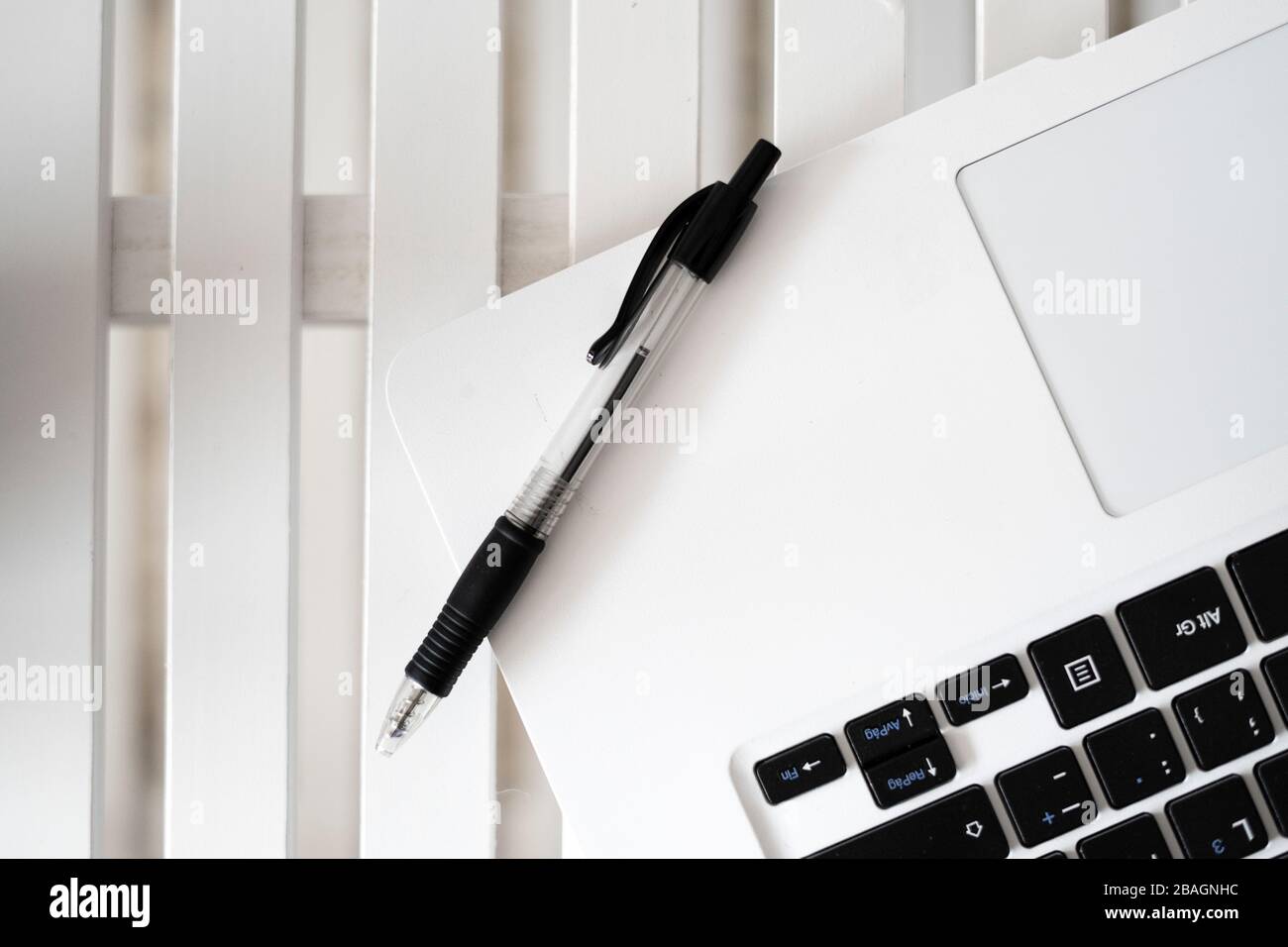 Black pen on top of a white laptop. Black pen concept Stock Photo Alamy
