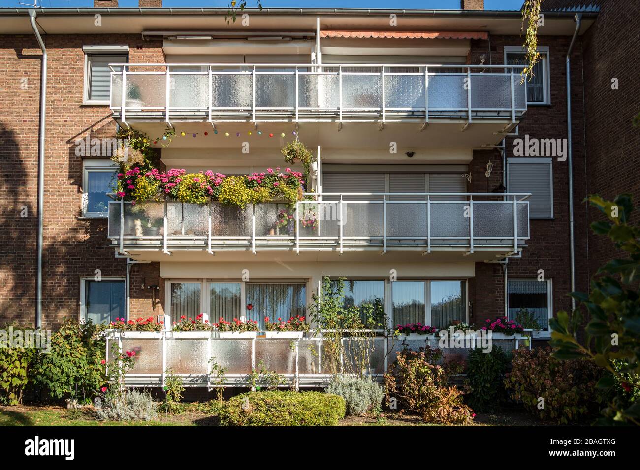 Traditional European residential house with balconys with colorful flowers and flowerpots