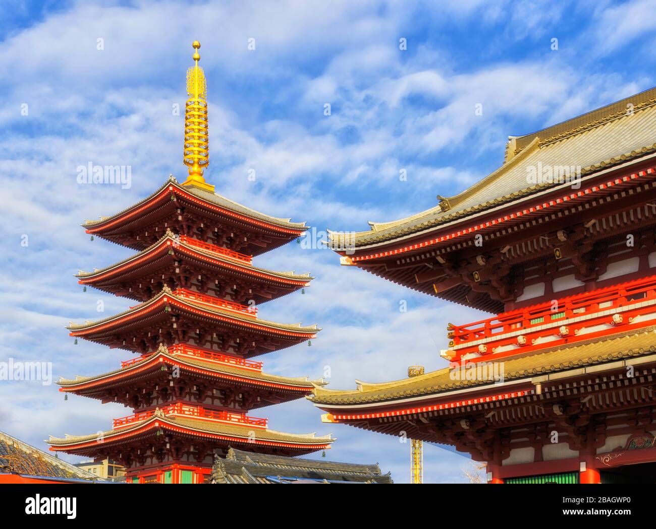 Red-white golden pagoda tower at Senso Ji in Asakusa of Tokyo on a sunny day against blue sky. Stock Photo