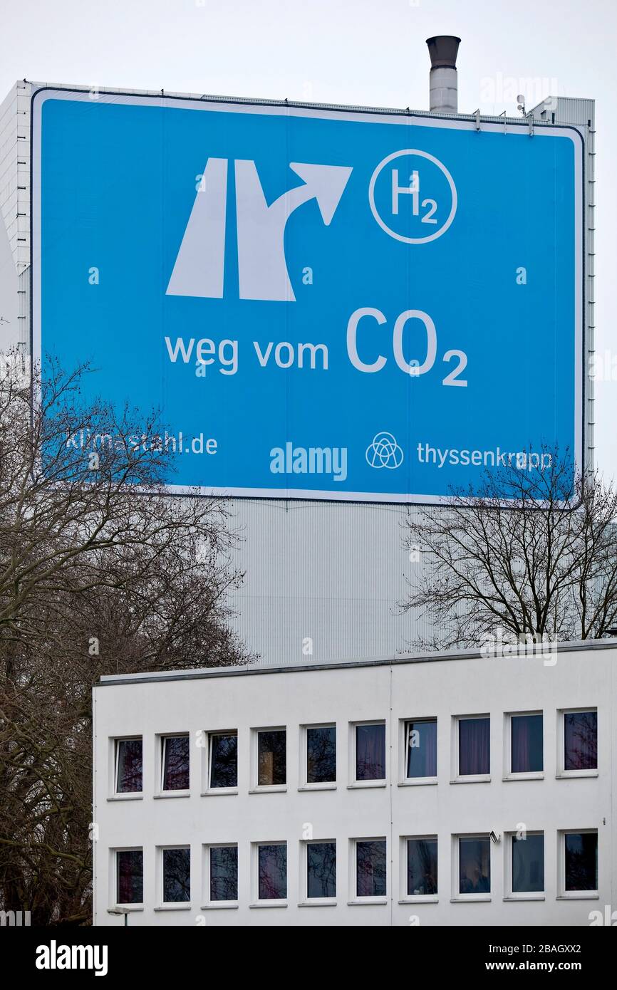 large-format poster near the motorway A 40, from CO2 to H2, Klimastahl, factory hall of ThyssenKrupp Steel Europe, Germany, North Rhine-Westphalia, Ruhr Area, Bochum Stock Photo