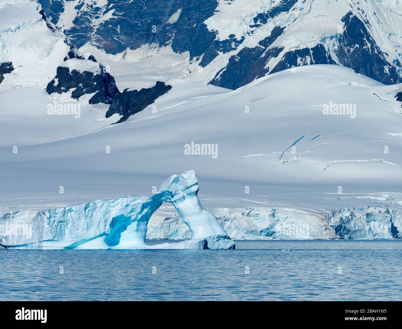 A huge iceberg arch in the Gerlache strait of the Antarctica peninsula as seen from an expedition ship Stock Photo