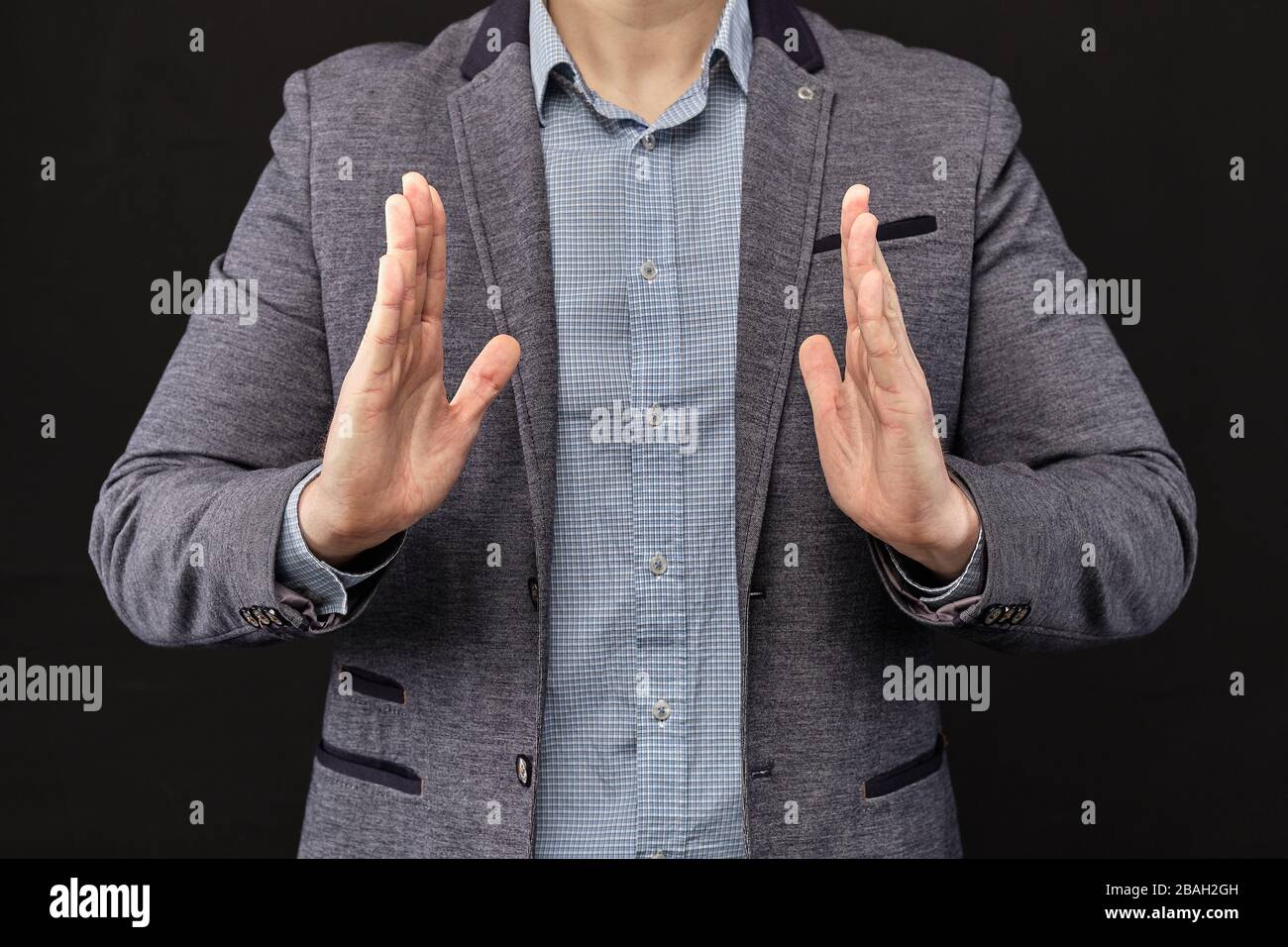 A man in a jacket shows with his hands an abstract object. Close up ...