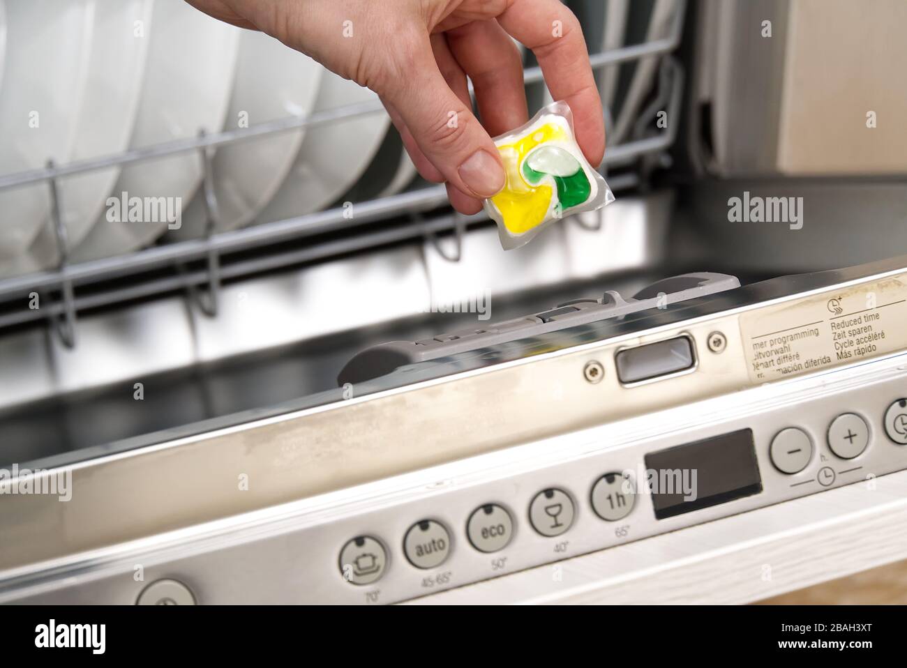Putting tab into full dishwasher close up. integrated dishwasher