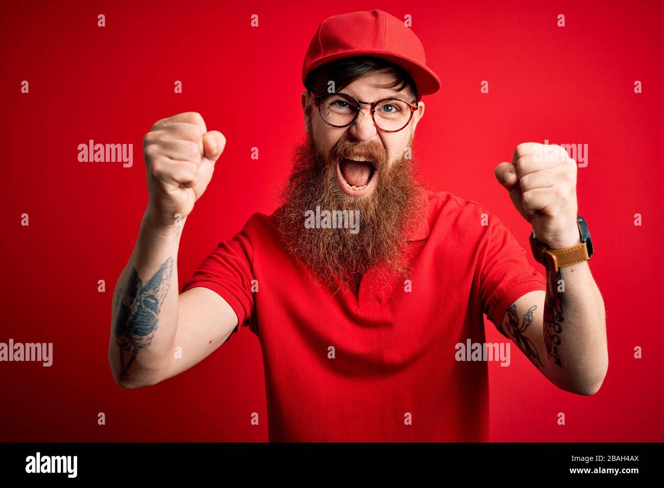Young handsome delivery man wearing glasses and red cap over isolated ...