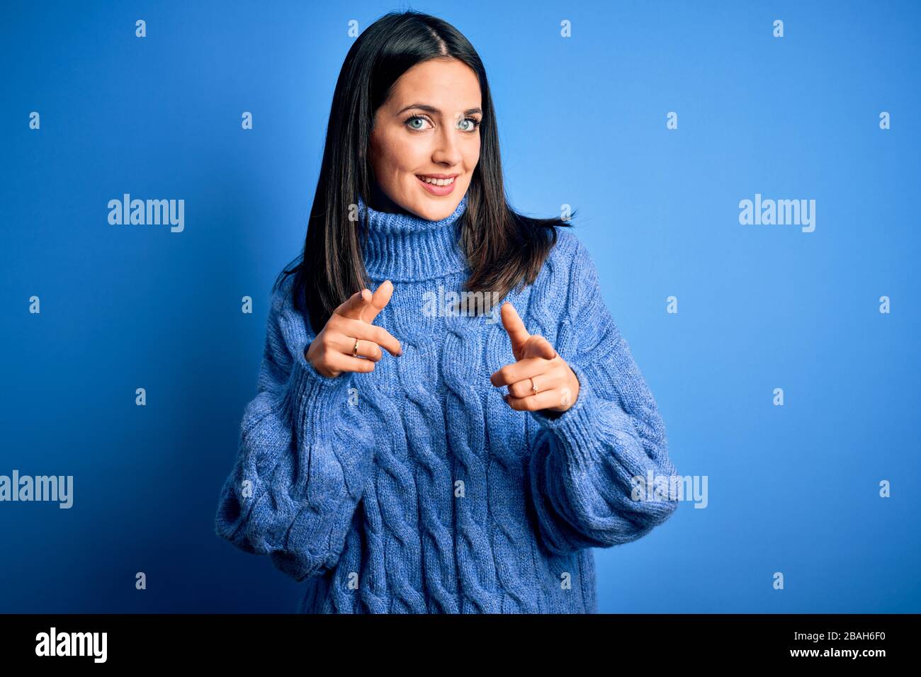 Young brunette woman with blue eyes wearing casual turtleneck sweater ...