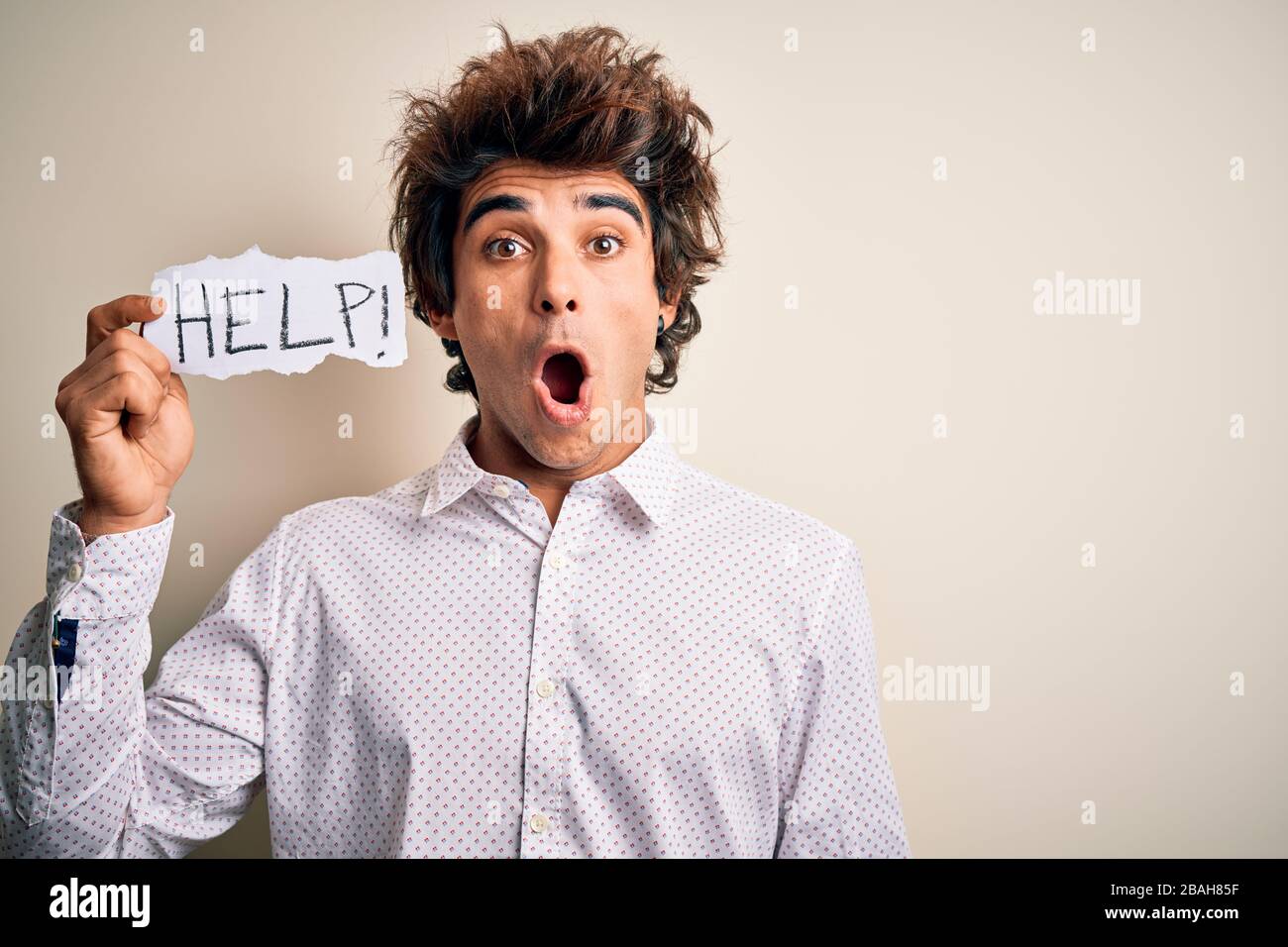 Afraid Paper Young handsome man holding paper with help message over isolated white ...