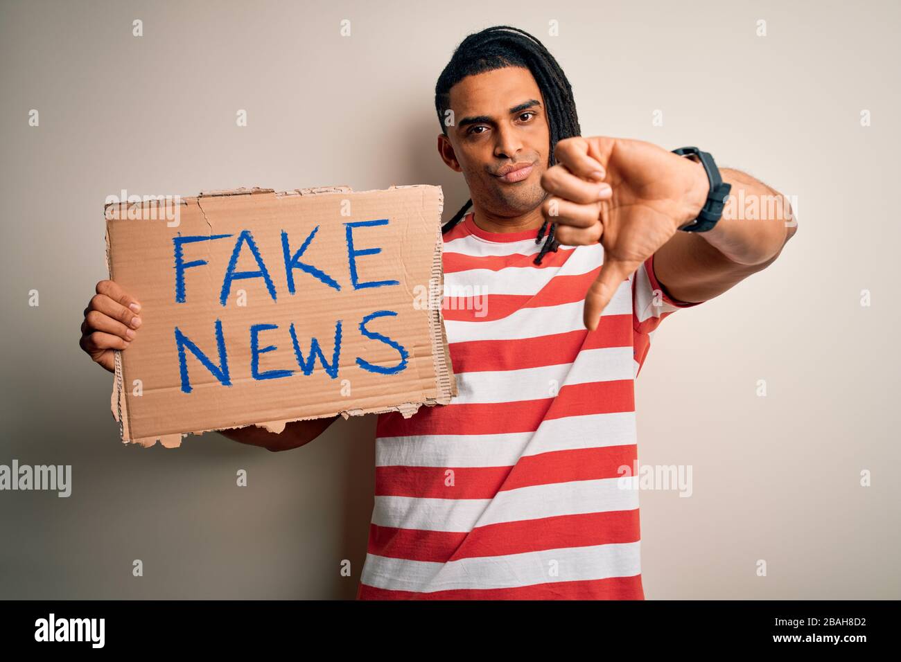 Young african american man with dreadlocks holding banner with fake ...