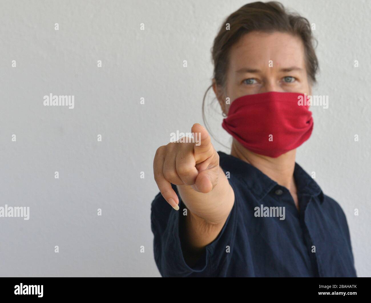 Caucasian woman poses for the camera with her DIY face mask (made from an old t-shirt sleeve) during the 2019/20 corona-virus outbreak. Stock Photo