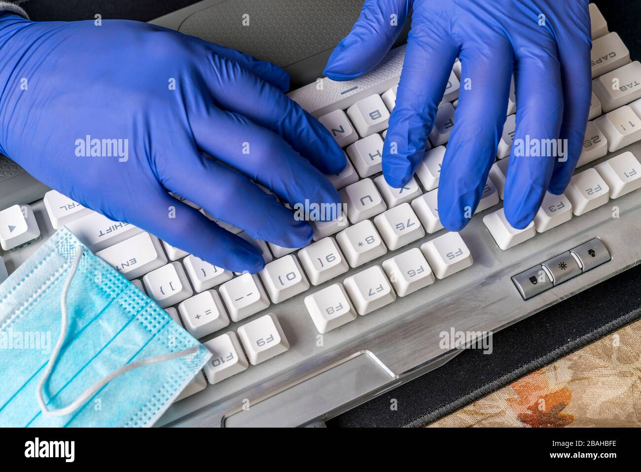 Typing on keyboard with gloves Stock Photo
