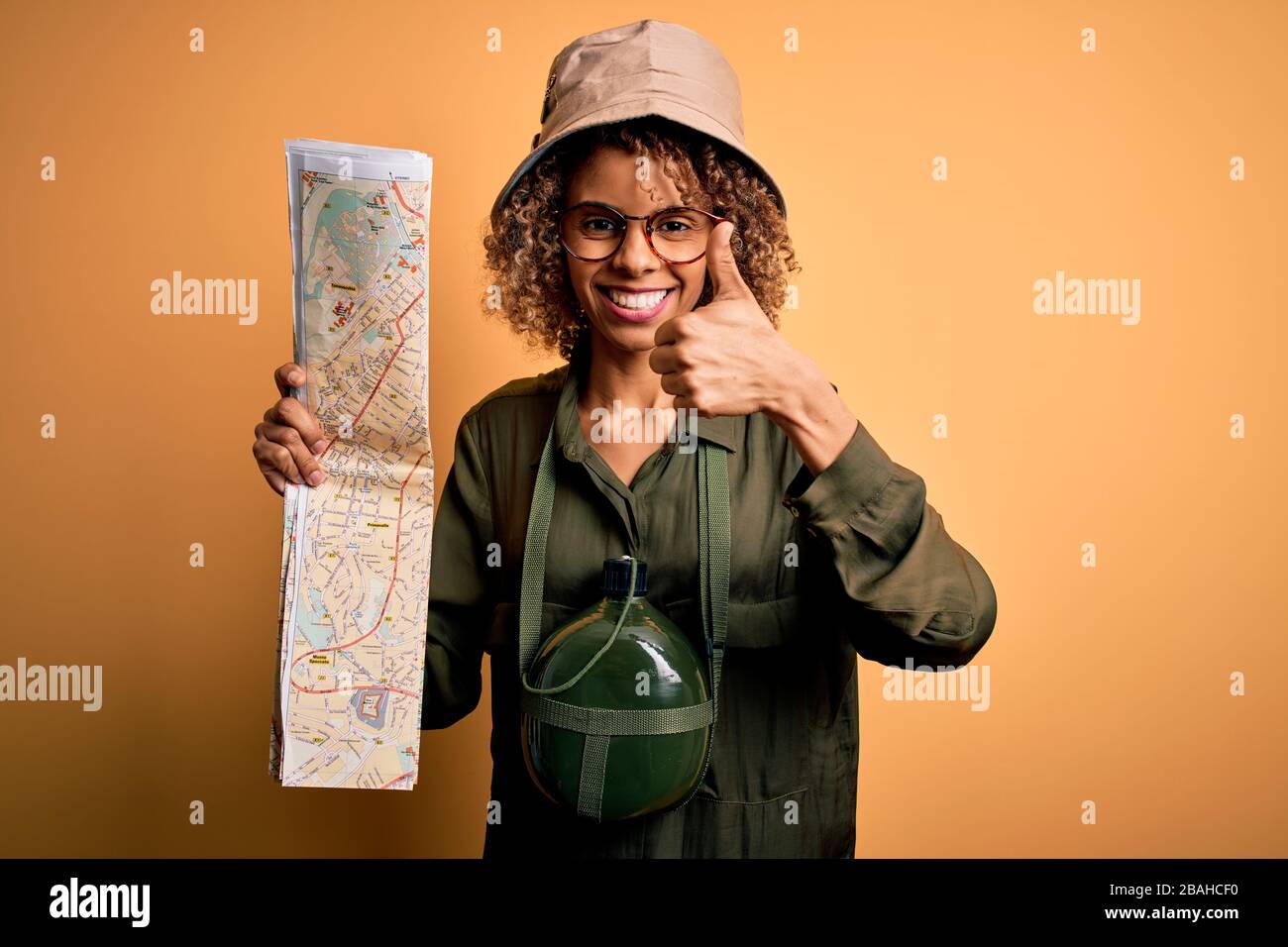 African american tourist woman wearing explorer hat and water canteen ...