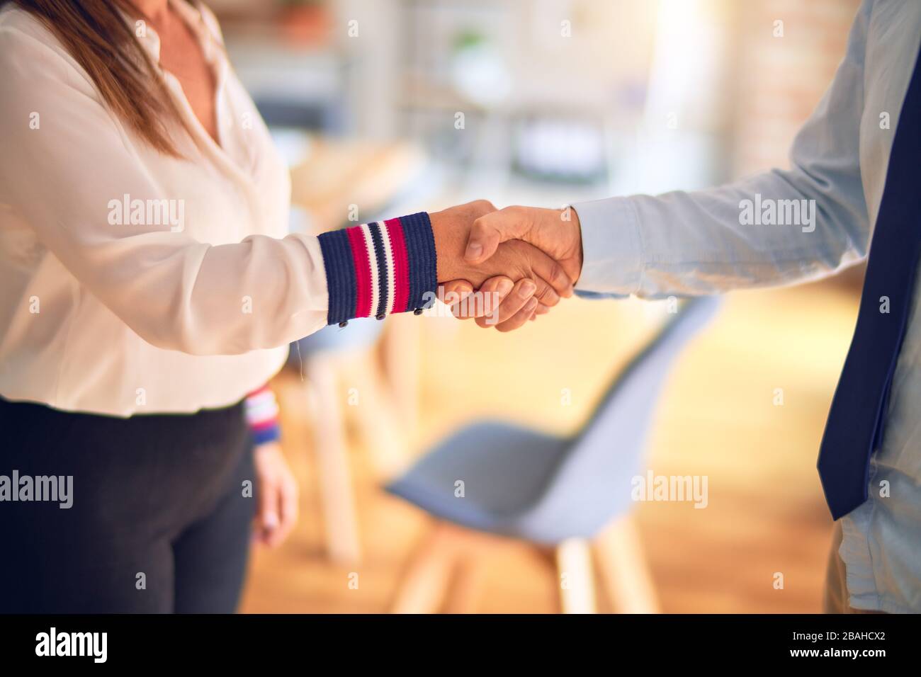 Two middle age business workers working together doing handsake at the office Stock Photo
