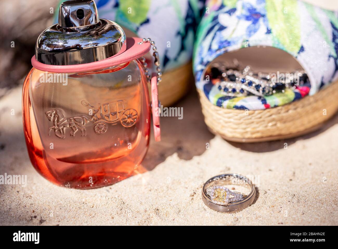 Wedding item splay at an exotic resort in Jamaica, including perfume, shoes, and wedding bands Stock Photo