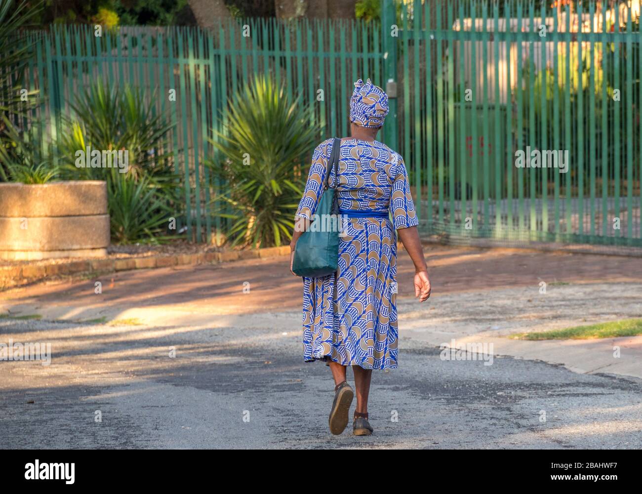 Alberton, South Africa: unidentified well dressed senior black African woman walks in a street in a residential neighbourhood Stock Photo