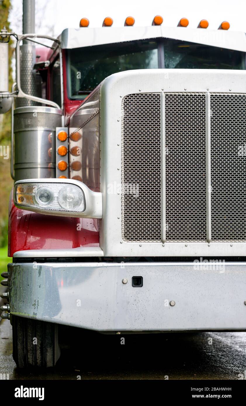 Big rig bonnet diesel industrial wet red semi truck chrome accessories  standing on the street road parking in raining weather waiting for cargo  load f Stock Photo - Alamy