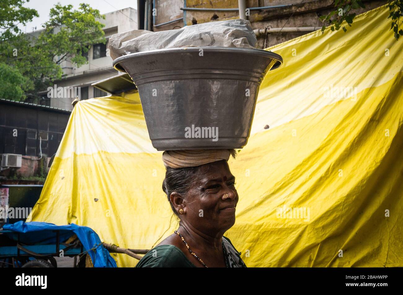 Woman walking with a load on her head, Chennai, India Stock Photo