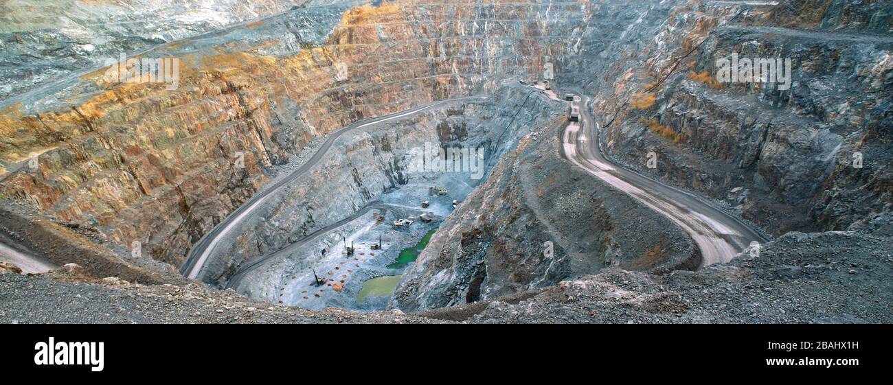 In the gold mine,  a large yellow truck carrying gold ore to the processing machine, panorama view Stock Photo