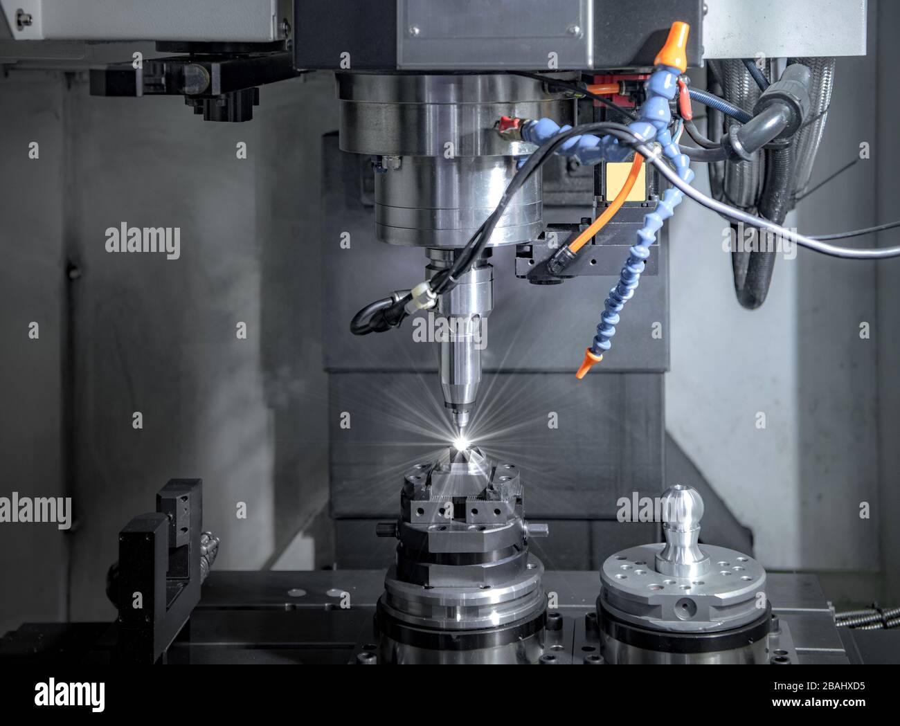 High precision CNC milling machine, operator machining metal part process in factory Stock Photo