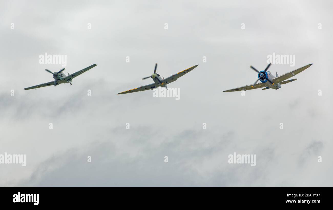 SEPTEMBER 19, 2015, EVERETT, WA: From left to right, a German BF-109, British Spitfire, and American P-47 fly in formation. Stock Photo