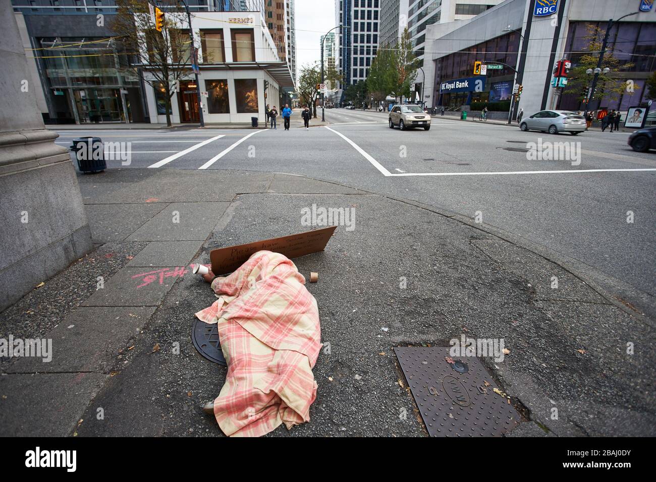 A homeless person is seen begging on the street in downtown Vancouver, Canada, on Monday, Oct 14, 2019. Stock Photo