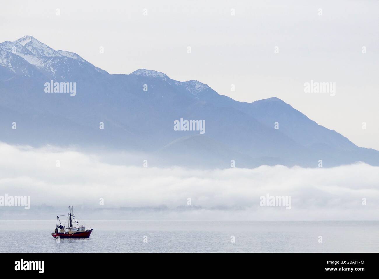 Fishing boat in Kaikoura with snowy mountain backdrop Stock Photo Alamy