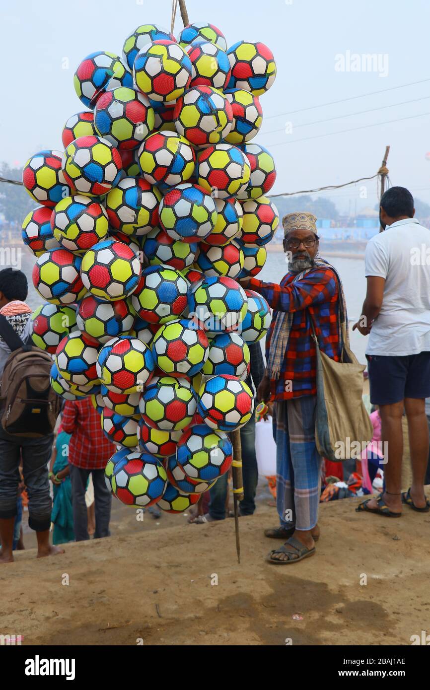 A Muslim man selling footballs toys or balloons for children at medaram jaathara, jappanna vaagu river, warangal tealangana. Stock Photo