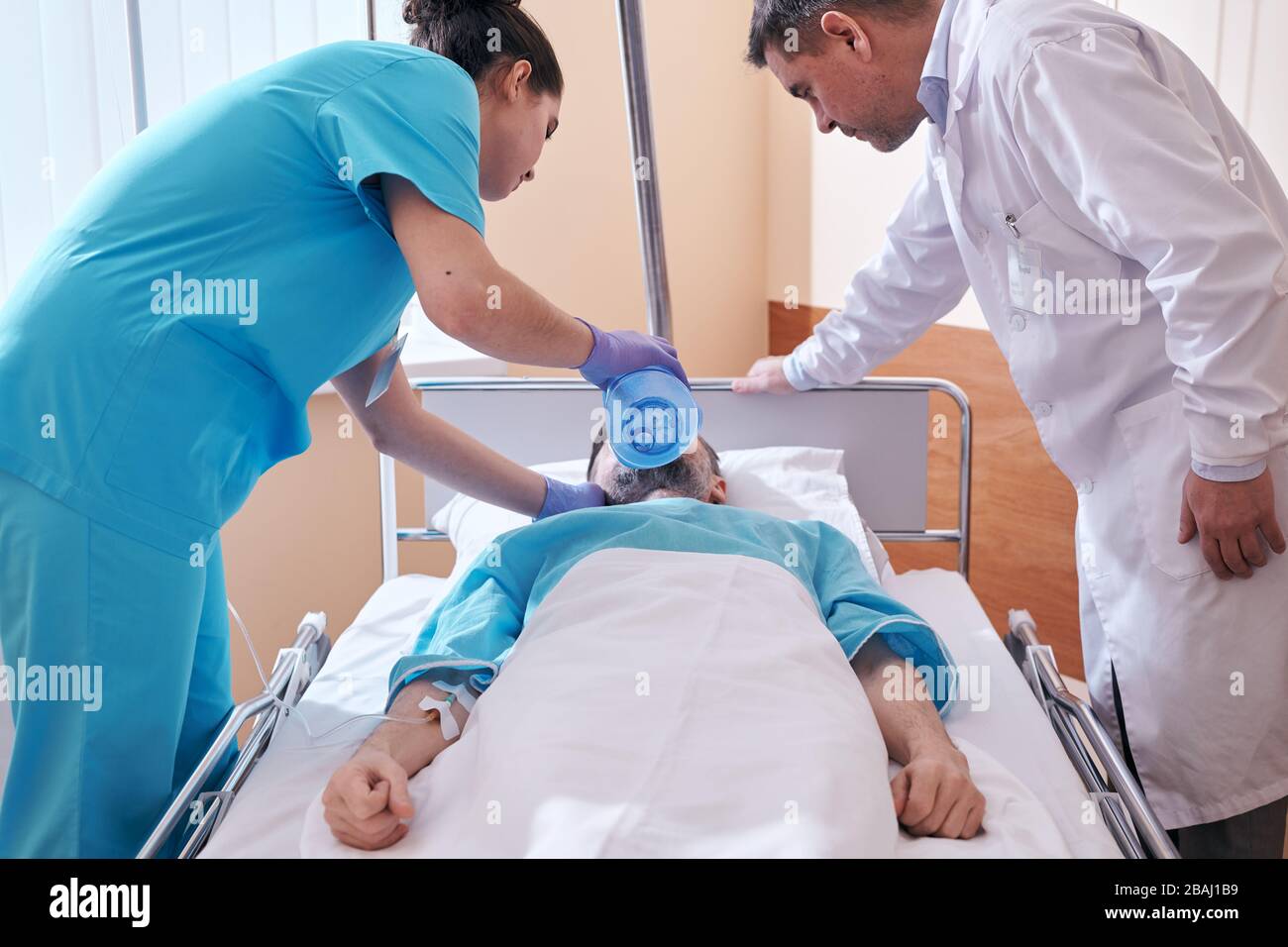 Nurse using bag valve mask while providing ventilation to patient in critical condition under