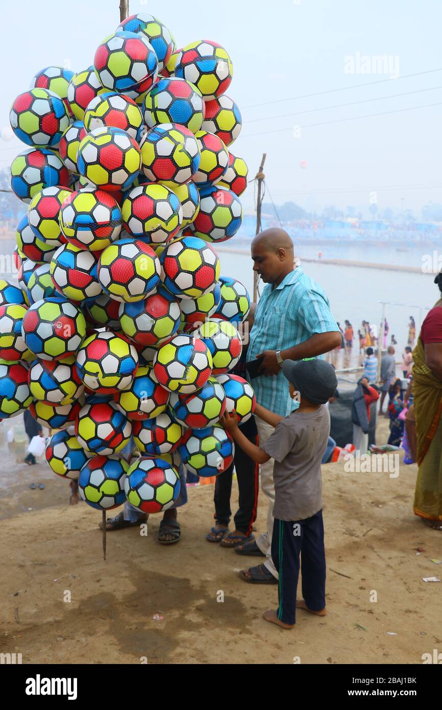 A father buying colorful balloon football for is sun seems to happy. at  jampanna vaagu river on medaram. Stock Photo
