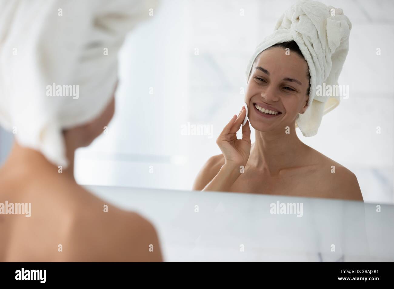 Woman cleanses skin using cotton pad and cosmetics products Stock Photo