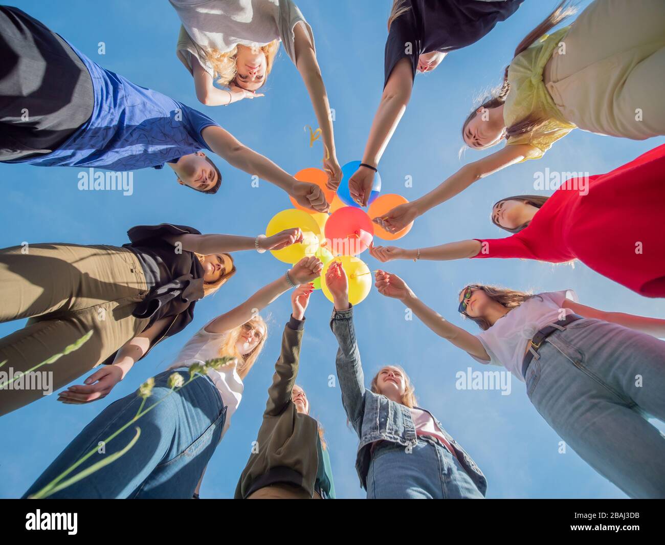 Friends are holding colorful balloons in their hands Stock Photo - Alamy