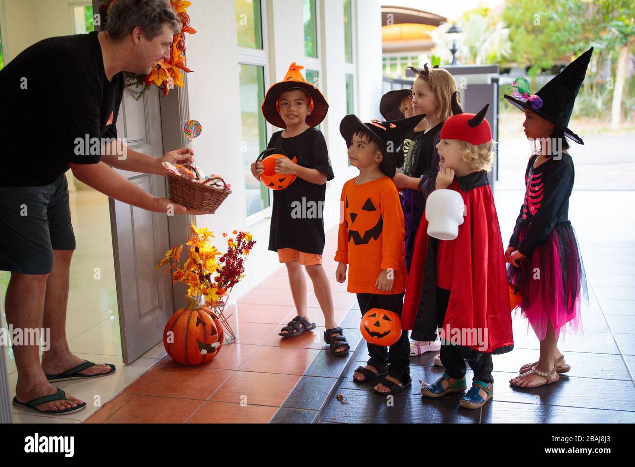 Kids trick or treat on Halloween night. Mixed race Asian and Caucasian ...