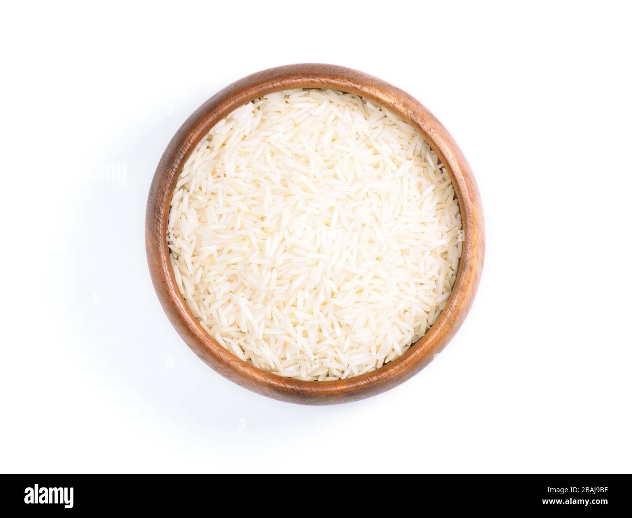 Indian long grain Basmati rice in brown wooden bowl isolated on white. Indian cuisine, ayurveda