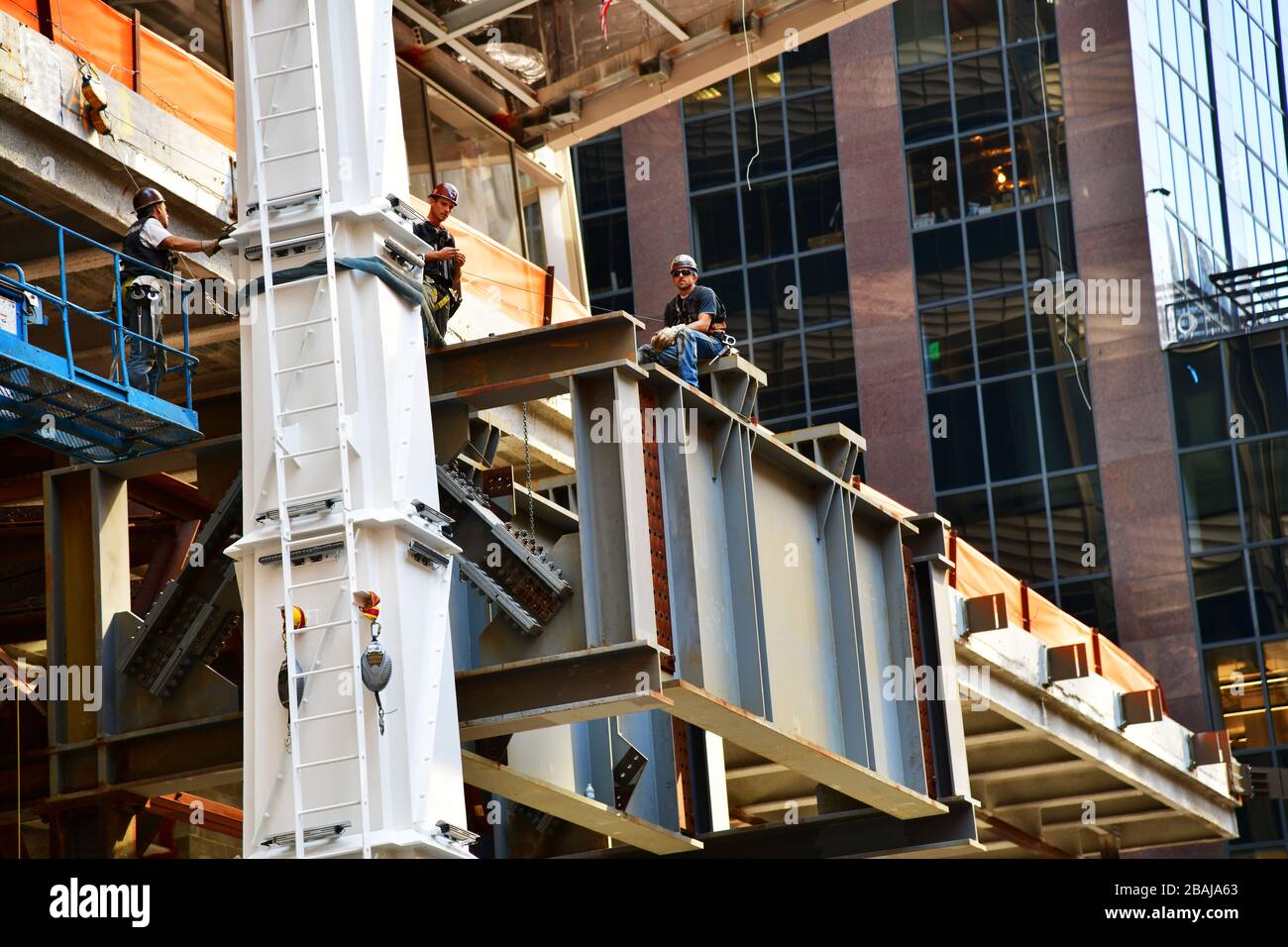 menclose up of construction workers high up on a new high rise in New York City during a break on one of the steel beams Stock Photo