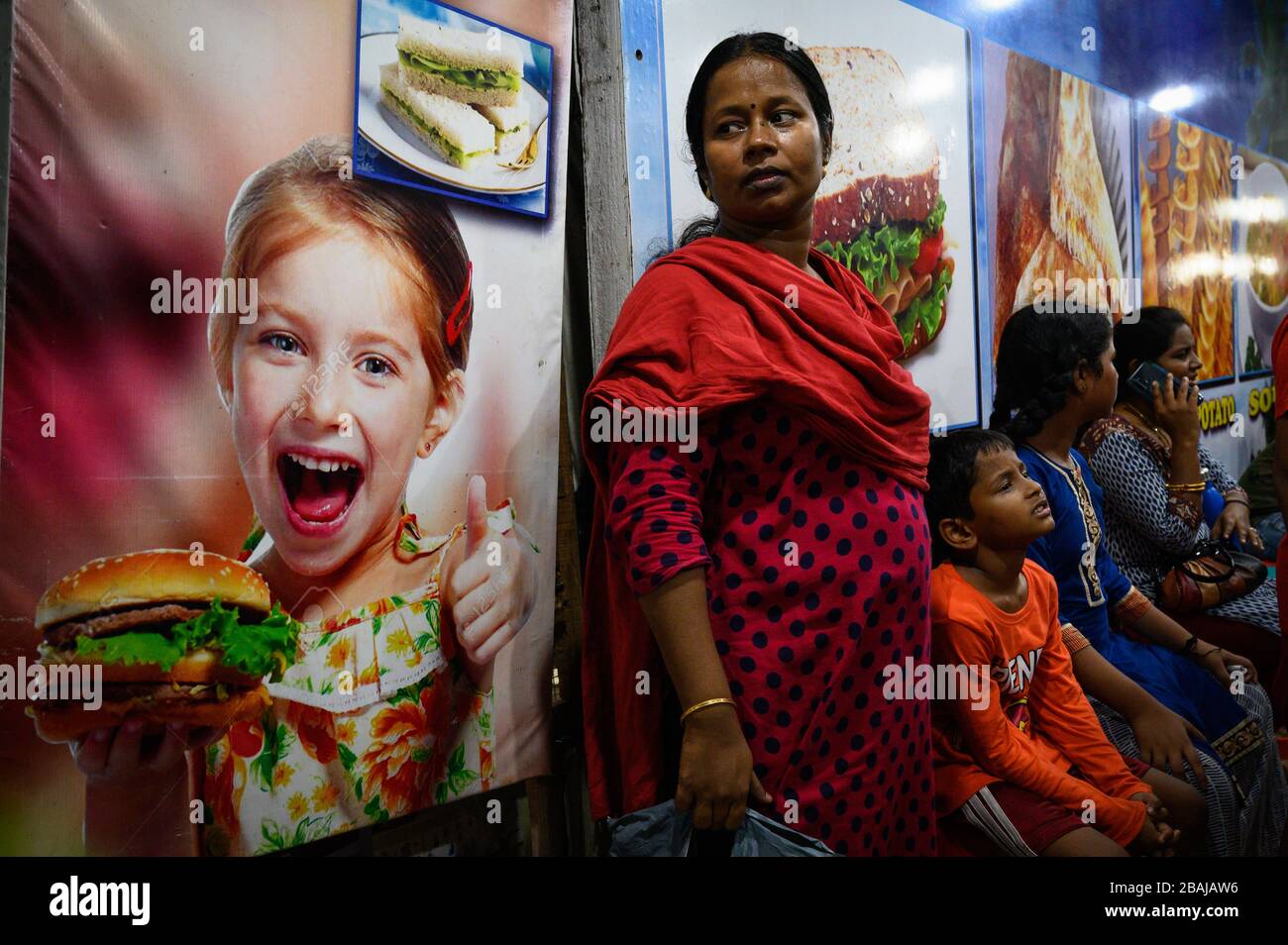 A woman and her children at a food stall on Marina Beach, Chennai, India Stock Photo