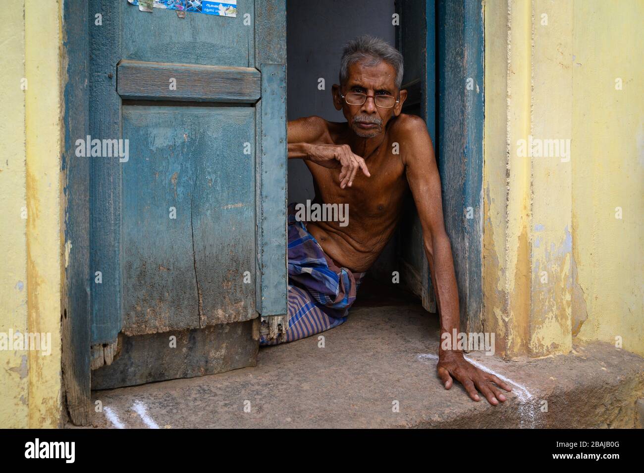 Portrait of a middle-aged man in the doorway of his home,  Madurai, India Stock Photo