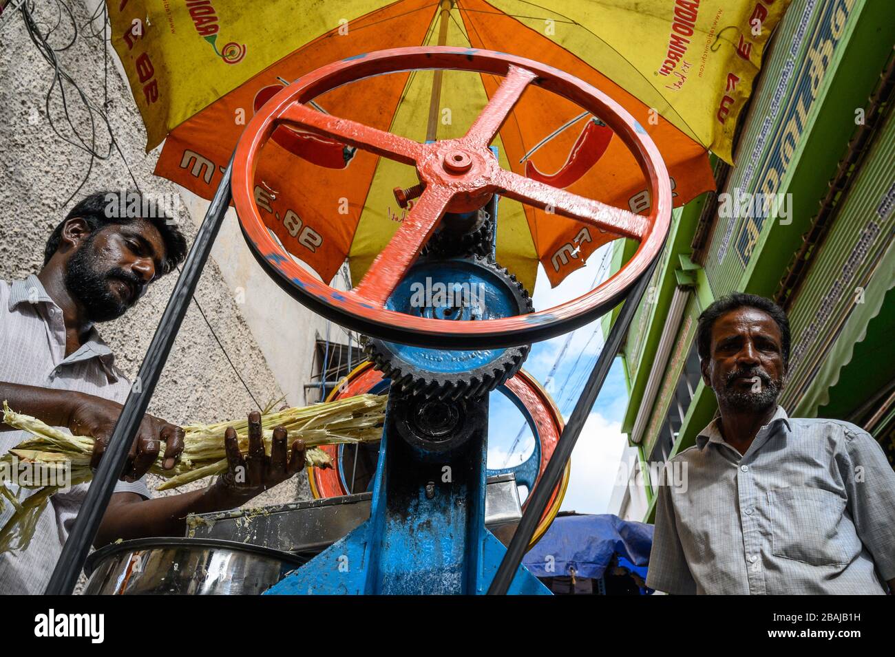 Man producing sugar-cane juice on the street in Madurai, India Stock Photo
