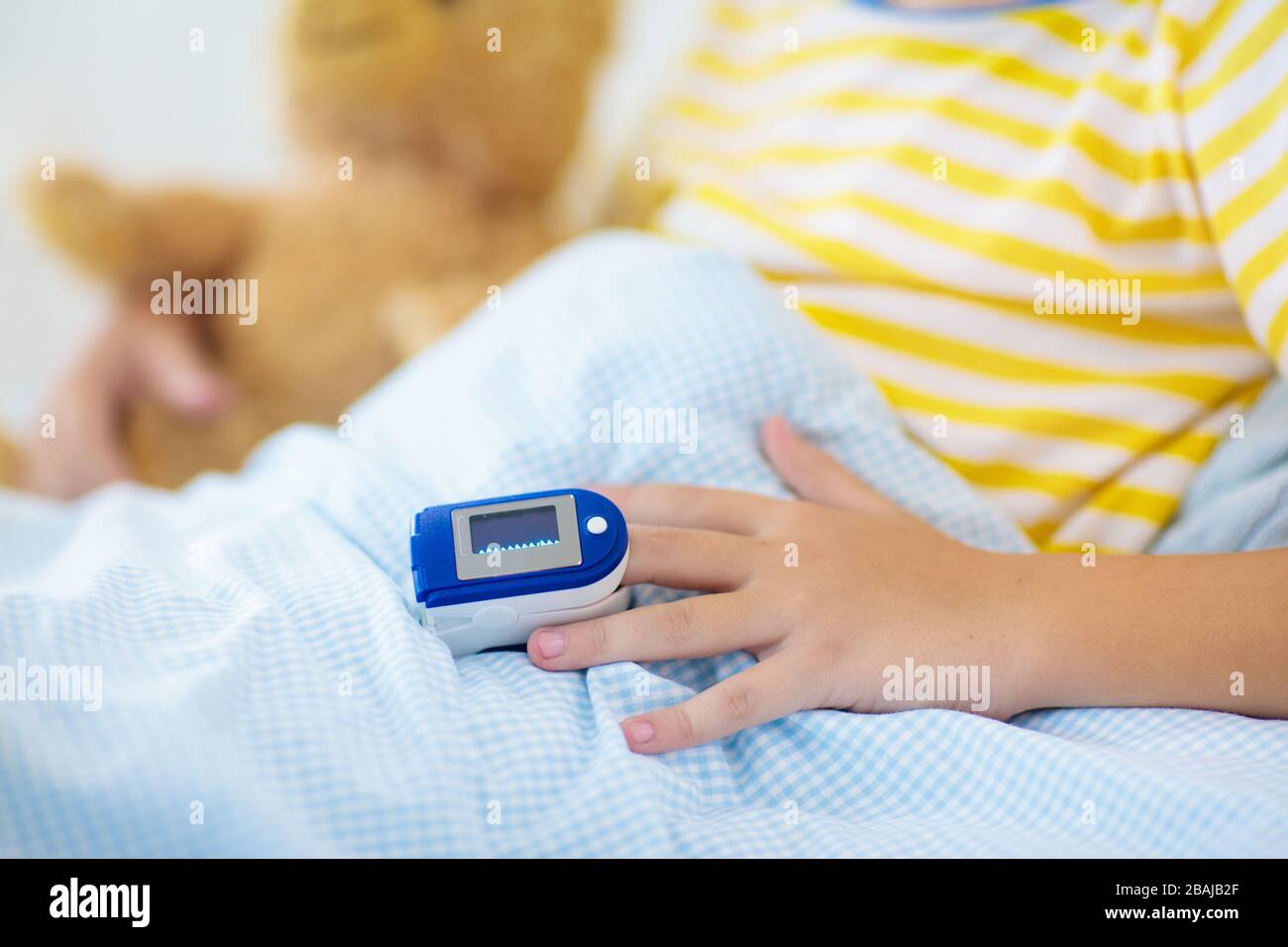 Sick little boy with pulse oximeter on his finger. Asthma treatment