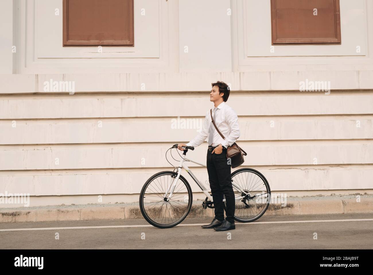 Outdoor portrait of handsome young man with fixed gear bicycle in the street. Stock Photo