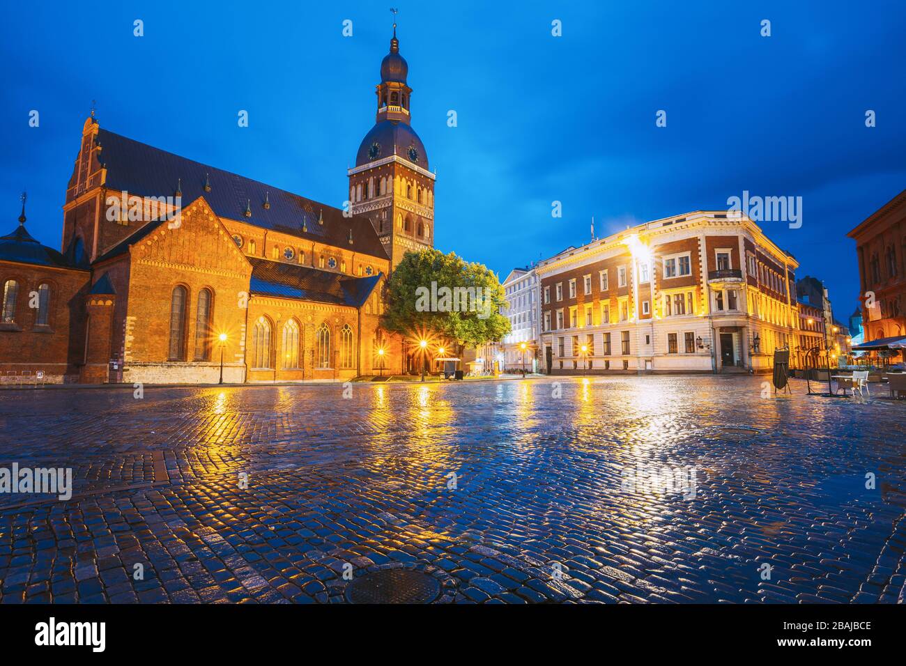 Riga, Latvia. View Of Dome Square And Dome Cathedral In Evening Illumination Under Blue Sky. Ancient Medieval Monument Of Old Town, Architectural Heri Stock Photo