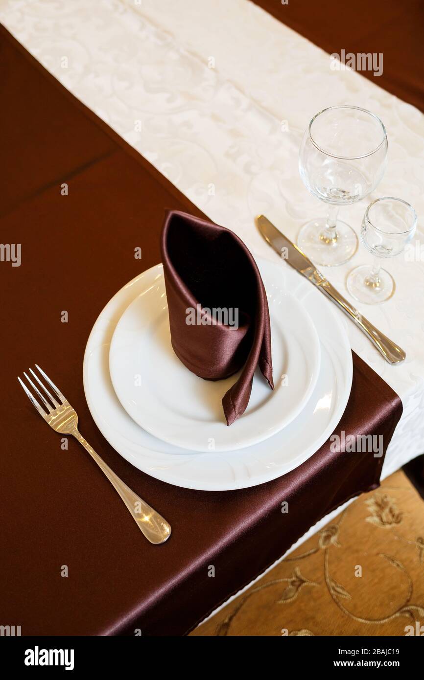 Table setting in a restaurant. Glass, plate, fork, knife Stock Photo