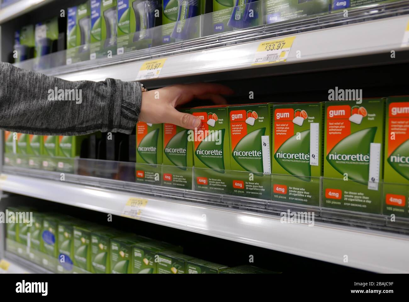 Woman taking nicorette gum inside Walmart store Stock Photo