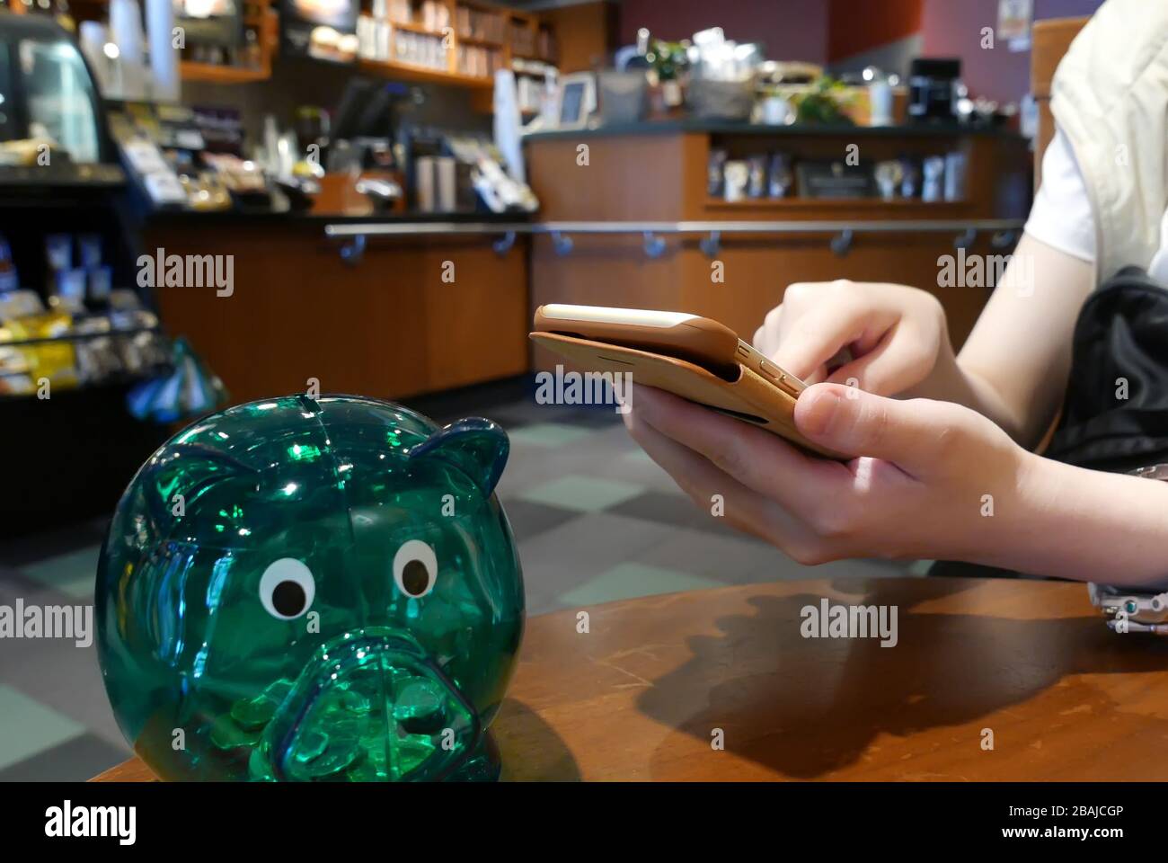 Hand browsing website on iphone inside Starbucks store Stock Photo