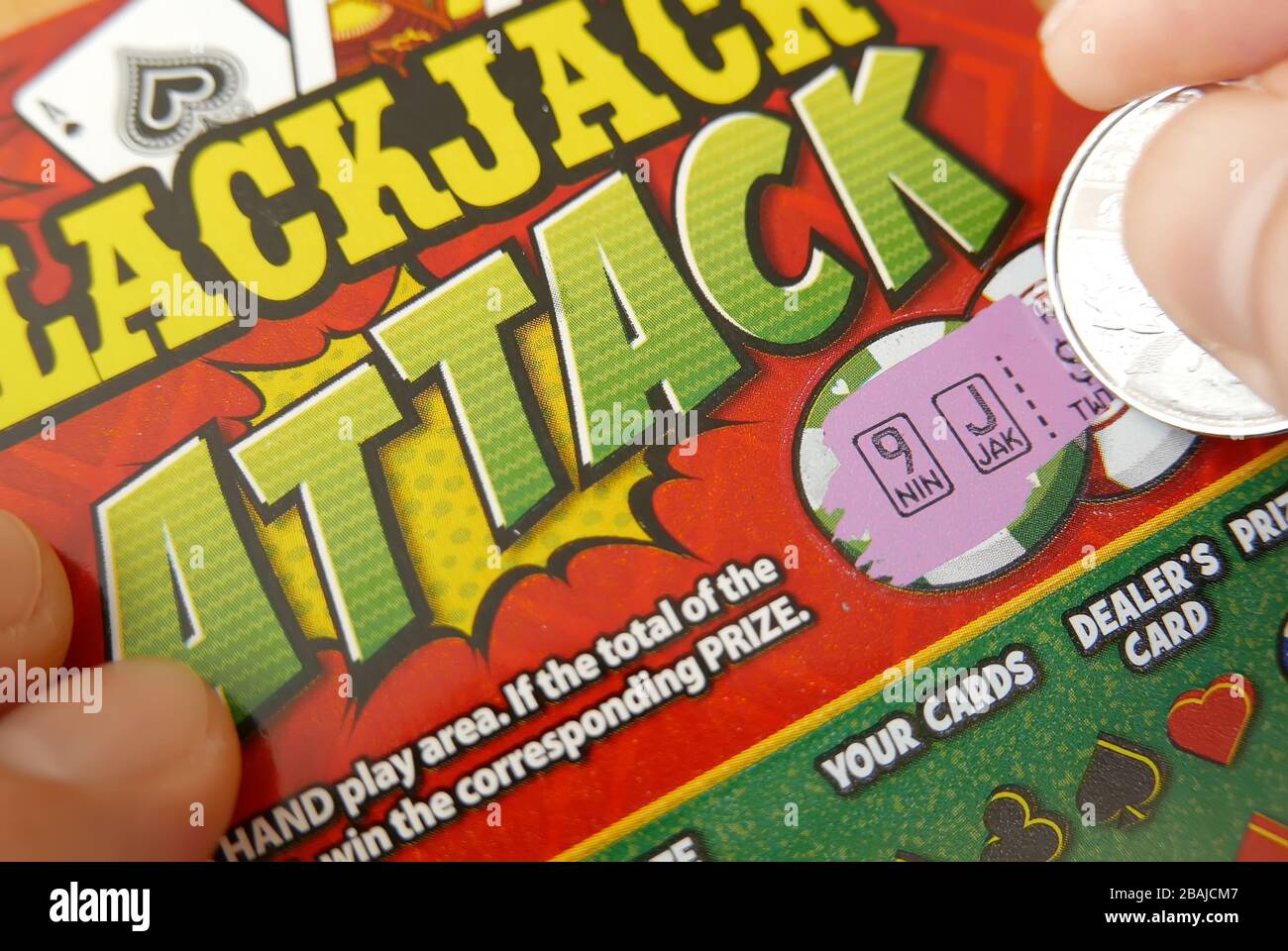 Close up man scratching blackjack attack lottery ticket bonus section Stock Photo