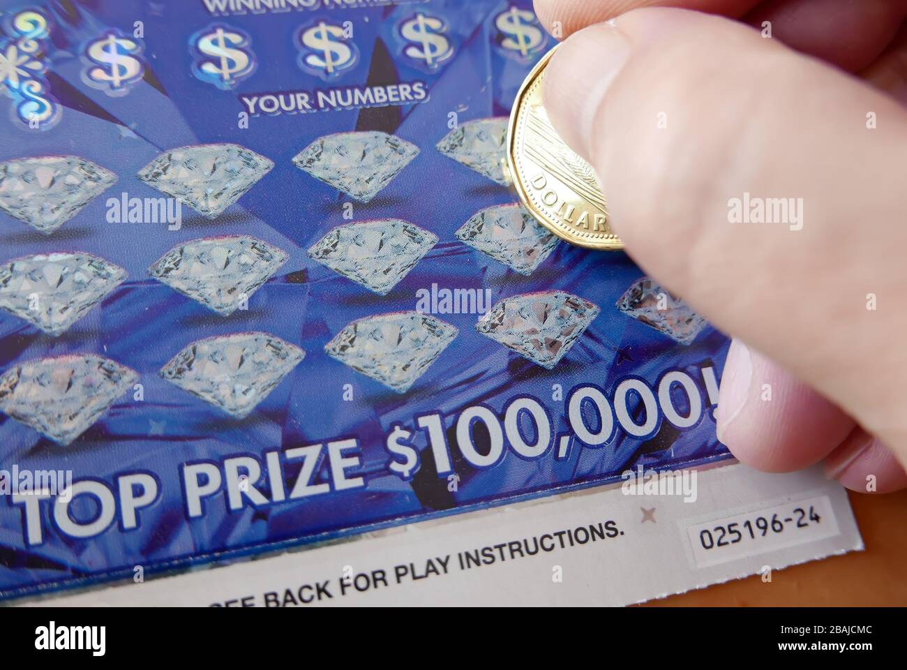 Close up man scratching diamond lottery ticket Stock Photo