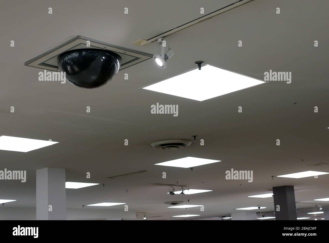 Dome security camera on top of ceiling inside Sears store Stock Photo