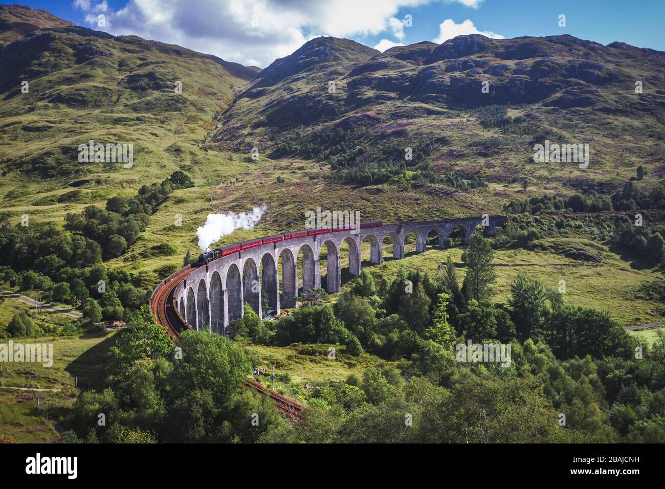 Glenfinnan Railway Viaduct in Scotland with the Jacobite steam train passing over. Stock Photo