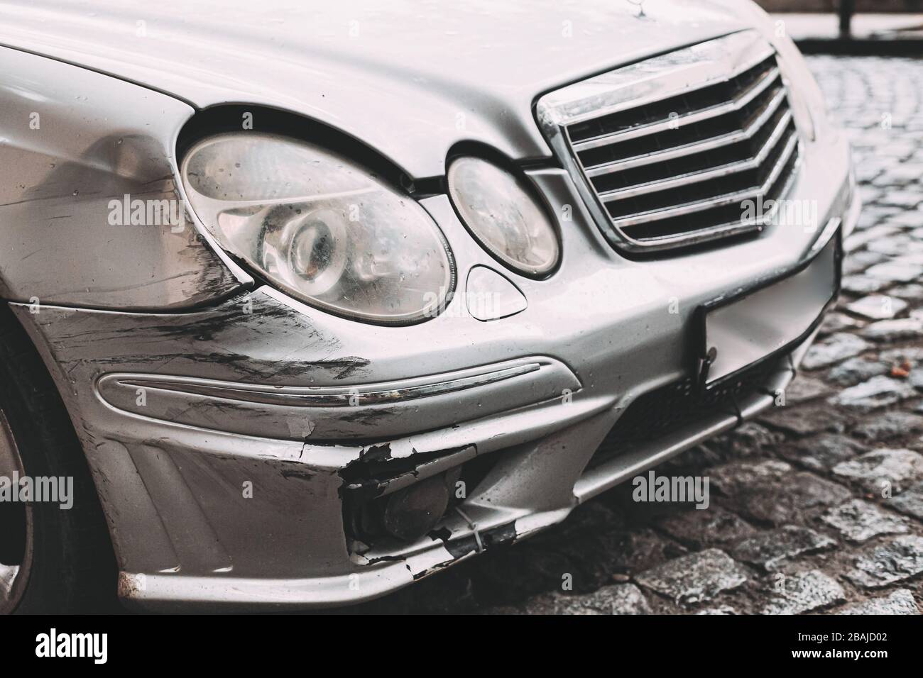 Broken Bumper Luxury Car Scratched With Deep Damage To Paint. Abandoned Car After Accident In City Street Stock Photo