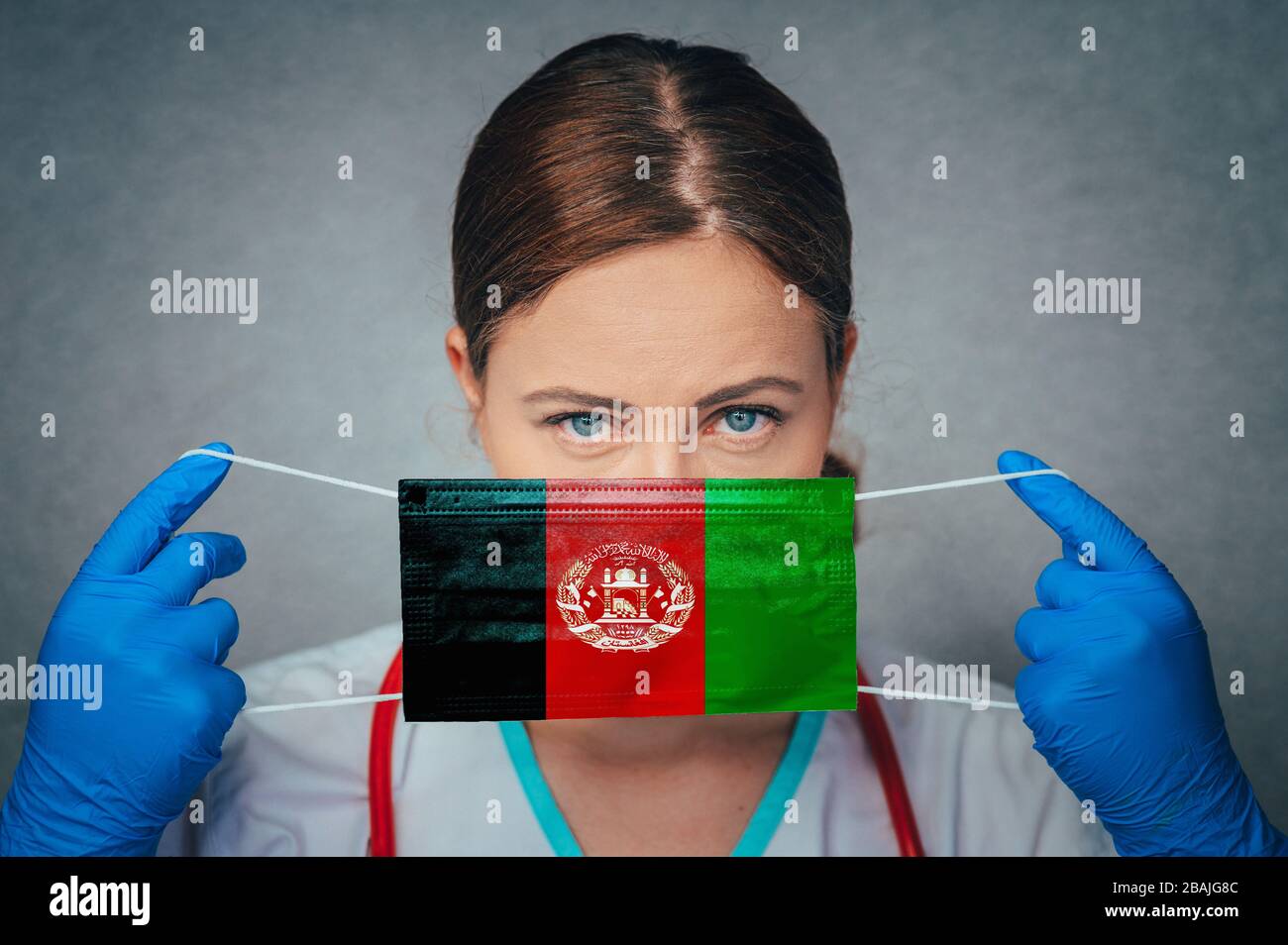 Coronavirus in Afghanistan Female Doctor Portrait hold protect Face surgical medical mask with Afghanistan National Flag. Illness, Virus Covid-19 in A Stock Photo
